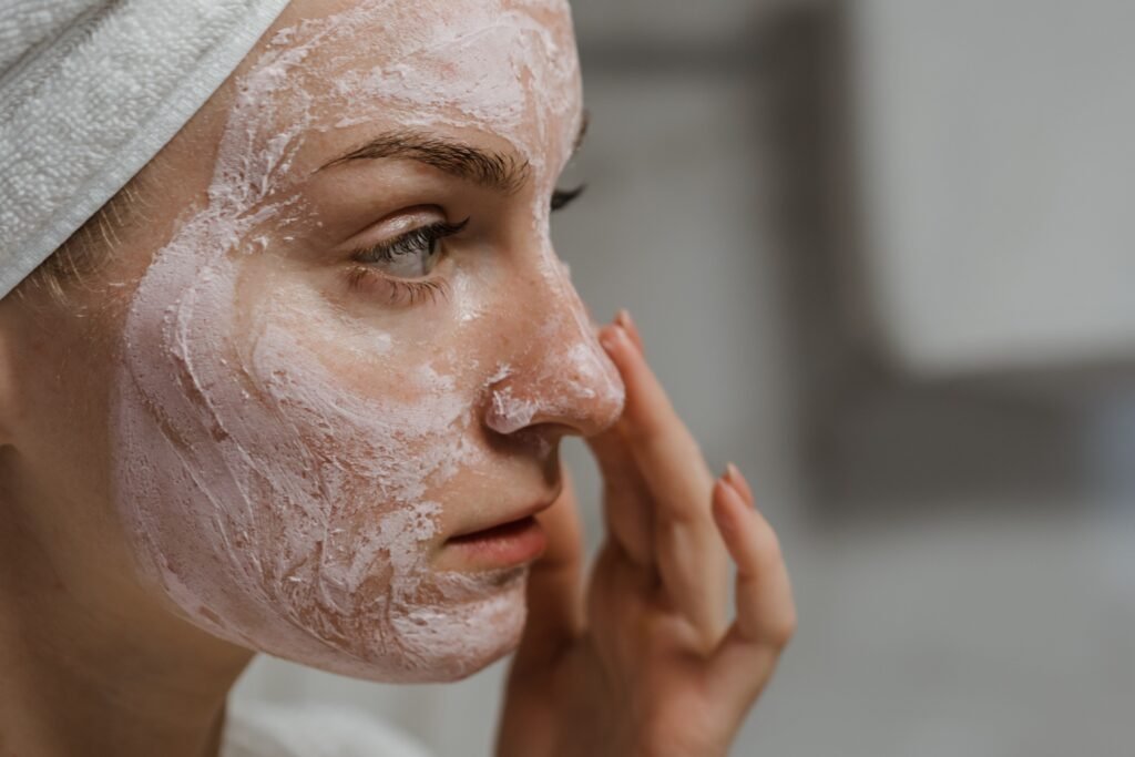 Joven aplicando su rutina facial de limpieza para la piel acneica.