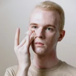 Joven aplicando una rutina fa facial para quitar marcas y cicatrices del acné.