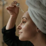 Mujer utilizando el mejor sérum con niacinamida para cuidar su piel acneica.