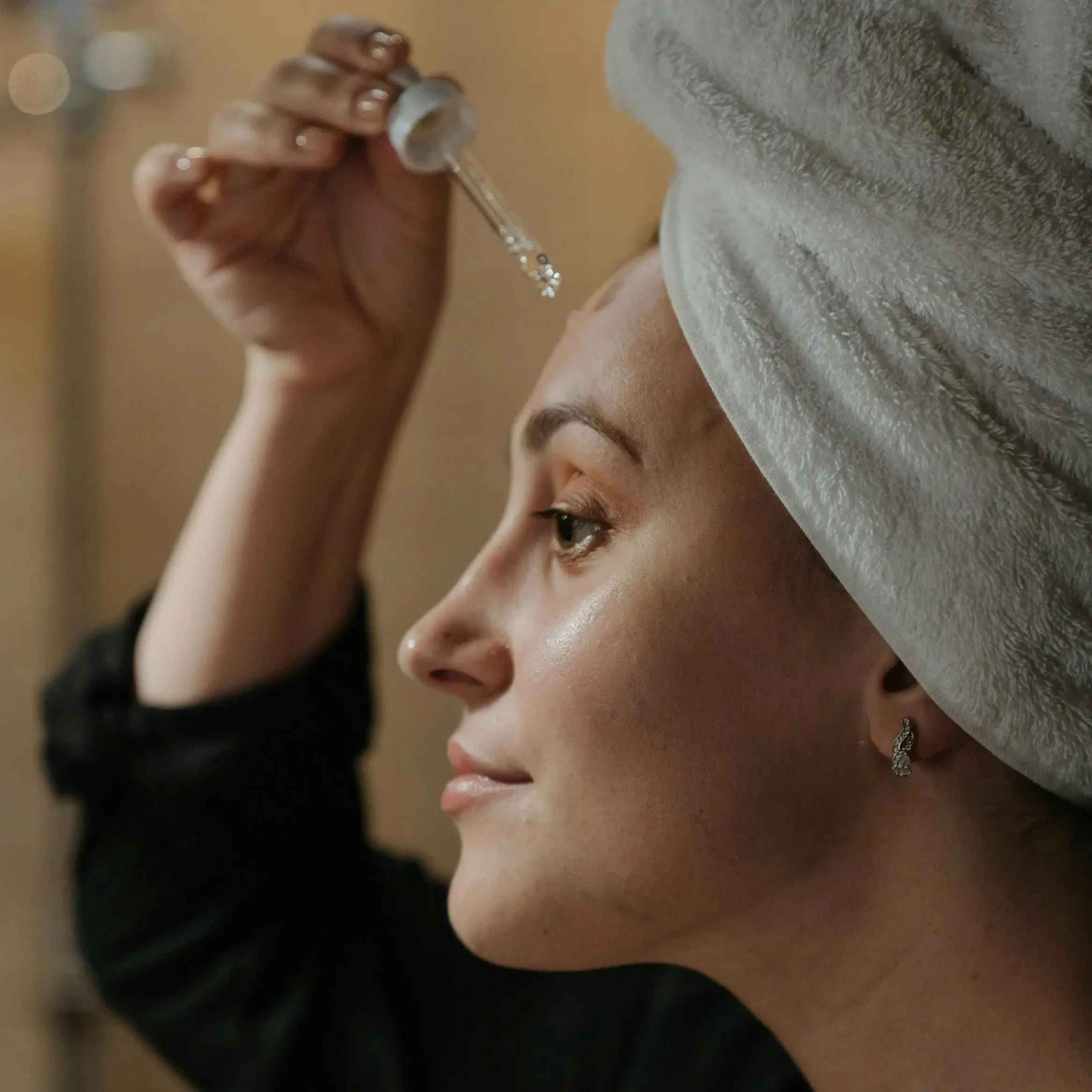 Mujer utilizando el mejor sérum con niacinamida para cuidar su piel acneica.